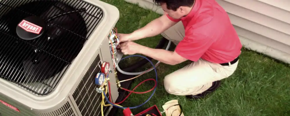 HVAC technician servicing an outdoor air conditioner unit in Ogden, UT