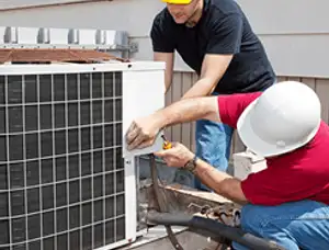 HVAC technicians repairing an outdoor AC unit on a rooftop in Ogden, UT
