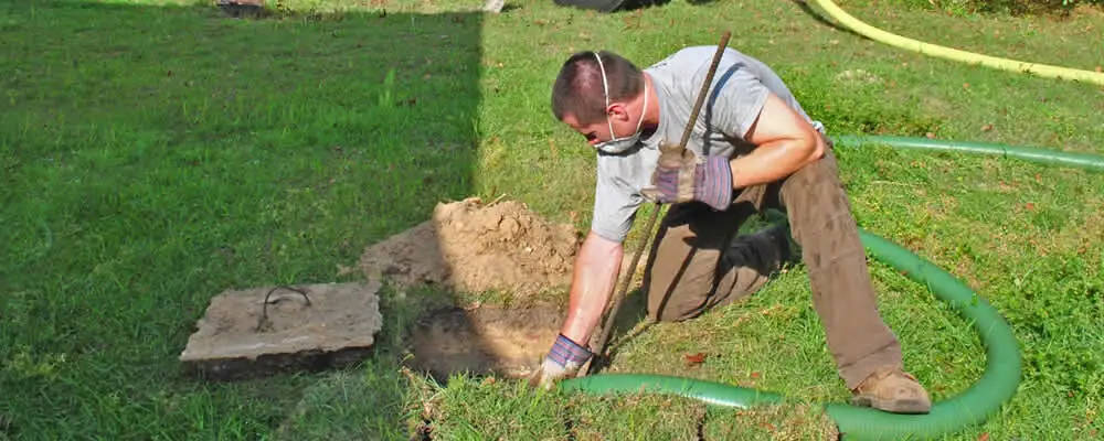 Septic pumping technician servicing a residential septic tank in Ogden, UT